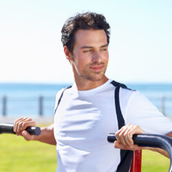 Athletic man working out his chest on a public park