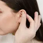 doctor examines girl ears before otoplasty