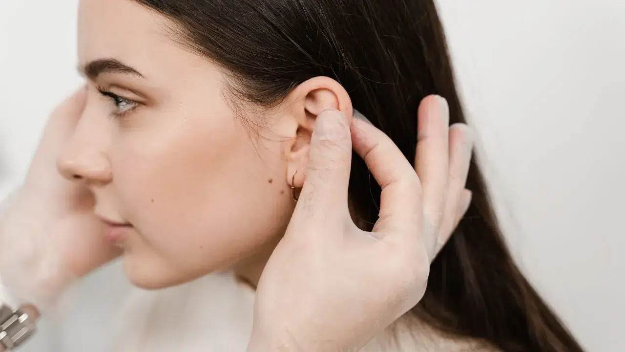 Top 5 Otoplasty Techniques Surgeons Use for Perfect Ear Symmetry doctor examines girl ears before otoplasty